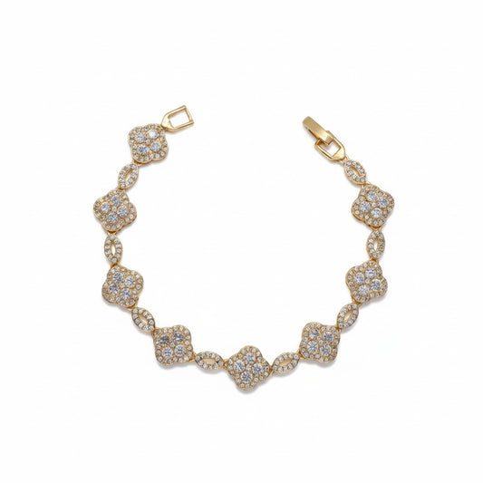 A gold plated bracelet featuring a series of pavé-set clear stones in clover and oval motifs, displayed on a clean white background.