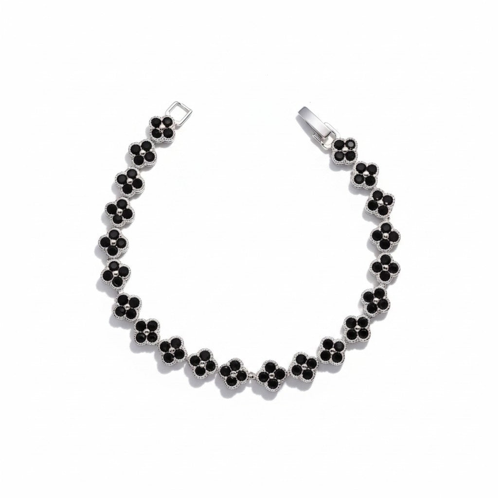 A silver-tone four clover chain bracelet with small black clover-shaped gemstones, displayed on a clean white background.