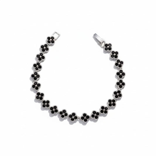 A silver-tone four clover chain bracelet with small black clover-shaped gemstones, displayed on a clean white background.