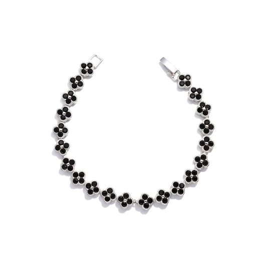 A silver-tone four clover chain bracelet with small black clover-shaped gemstones, displayed on a clean white background.