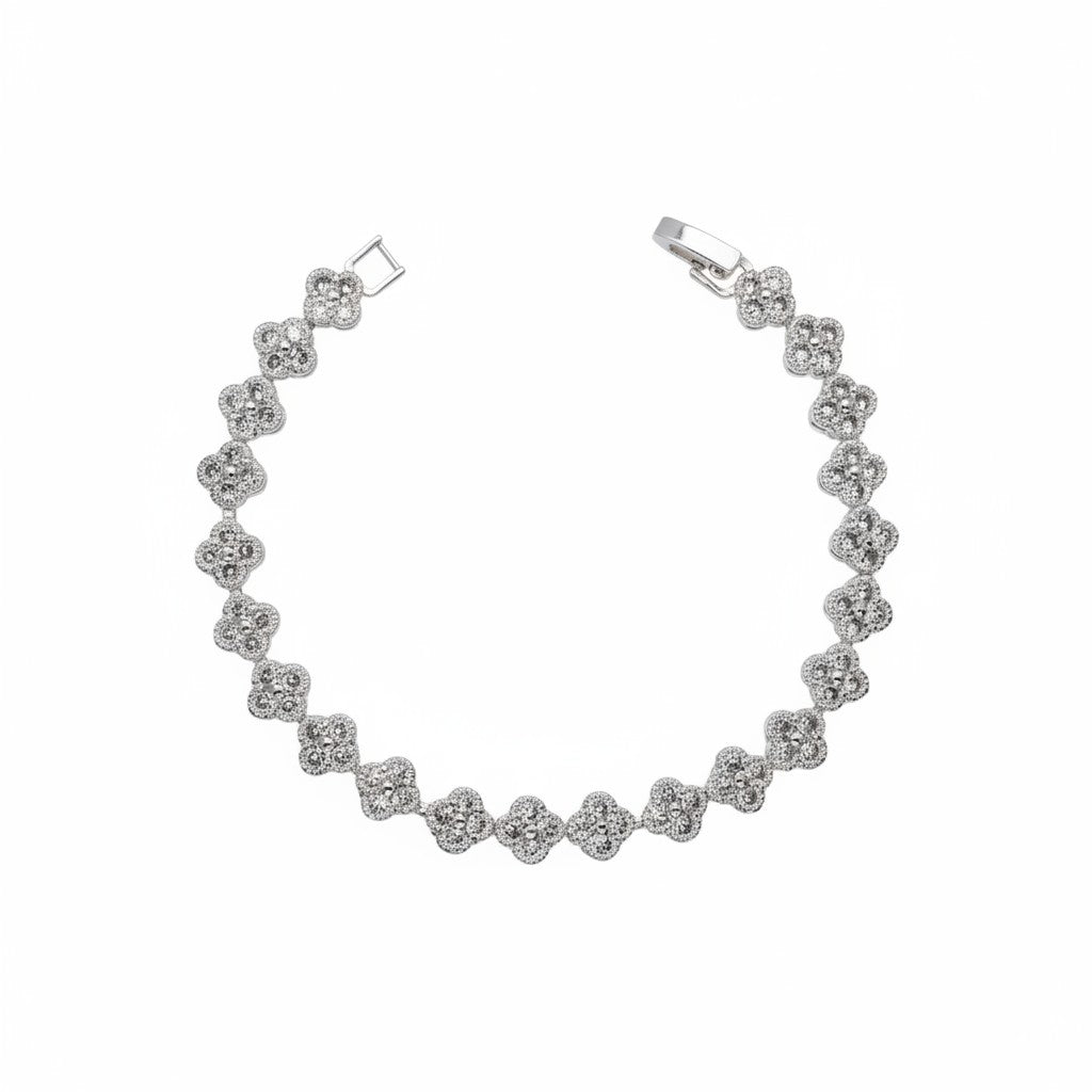 A silver tennis bracelet featuring a continuous row of small four-petal floral clusters, photographed on a solid white background.