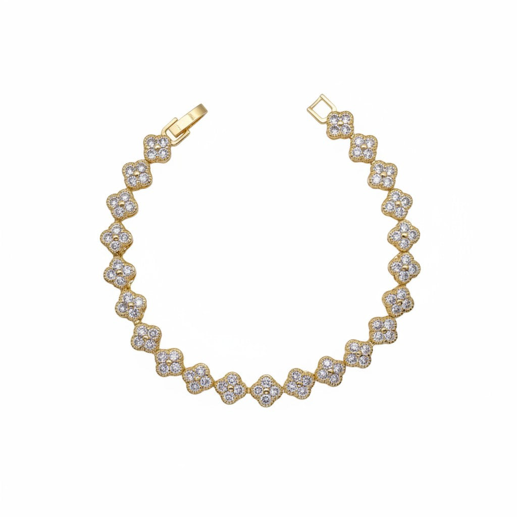 A gold plated bracelet featuring a continuous line of four-petal flower motifs paved with clear stones, shown on a plain white background.
