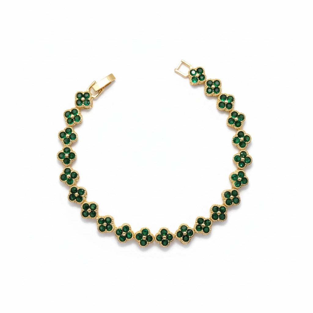 A gold-plated tennis bracelet featuring a repeating pattern of small five-petal flower clusters set with round green stones, shown on a plain white background.