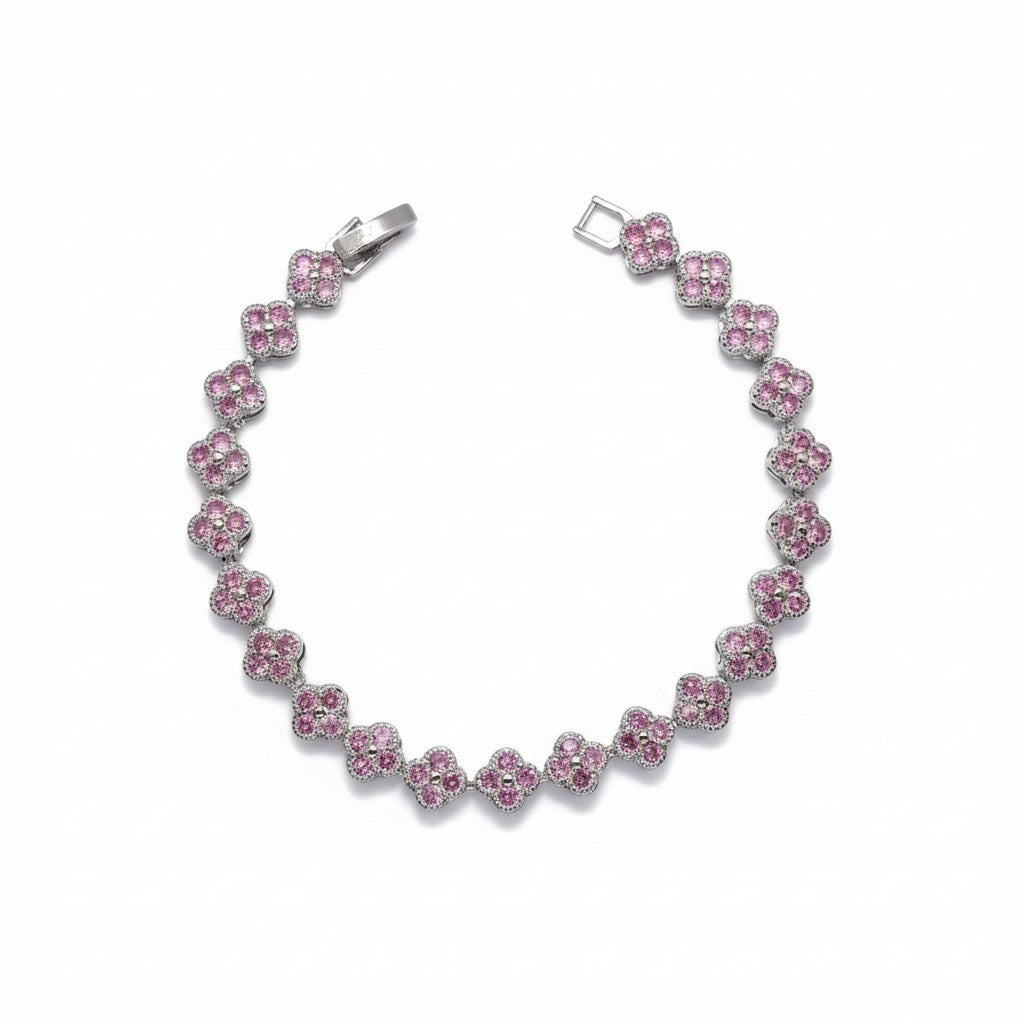 A silver-tone tennis bracelet featuring a series of pink gemstone clover motifs, displayed on a clean white background.