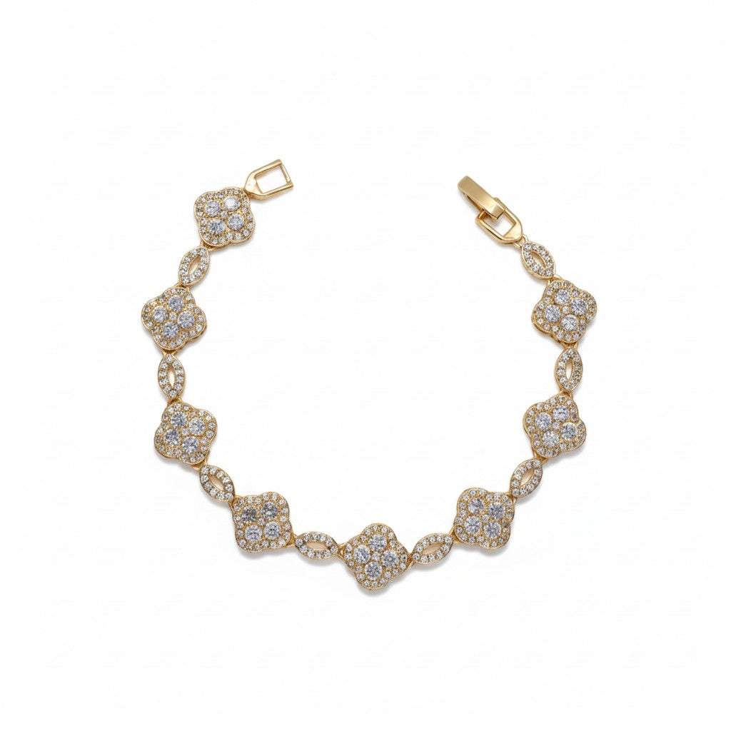 A gold plated bracelet featuring a series of pavé-set clear stones in clover and oval motifs, displayed on a clean white background.